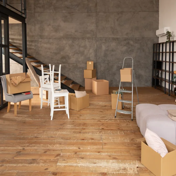 Une pièce commerciale remplie de boîtes et de meubles, prête à être aménagée ou à accueillir des clients.